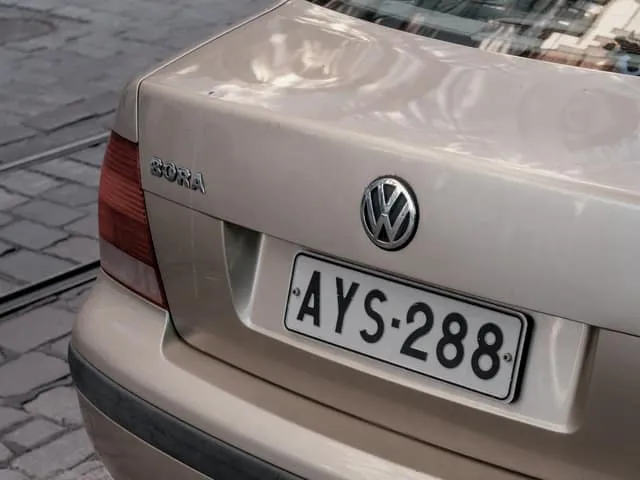 The rear of a saloon car parked on a cobbled street, its number plate visible.