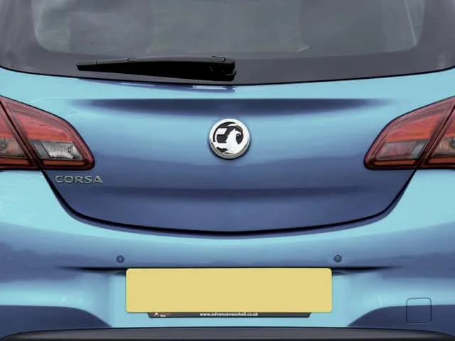 The rear of a small hatchback with a blank yellow plate.