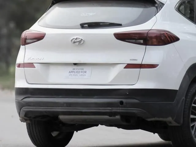 The rear of an SUV carrying a temporary “applied for” placard in place of a plate.